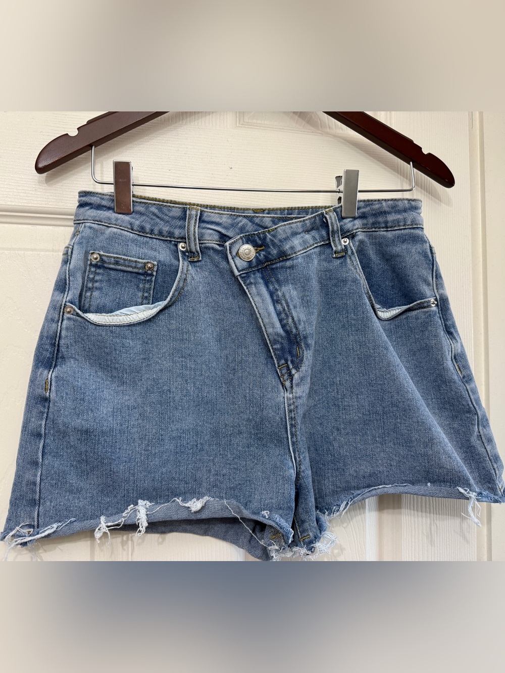 High-Rise Distressed Denim Shorts in Medium Blue